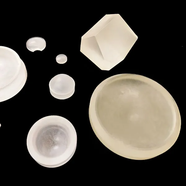 Optical glass blanks of different shapes, including discs and a prism block