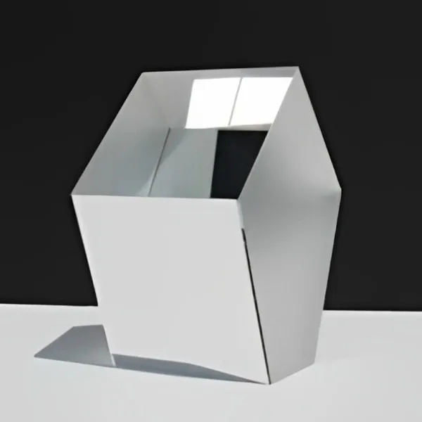Penta prism on a white surface against a black background