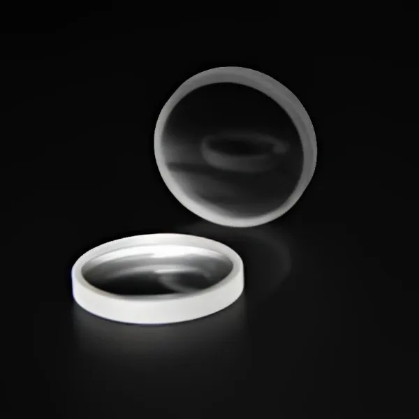 Two plano-concave lenses on black, one standing on its edge