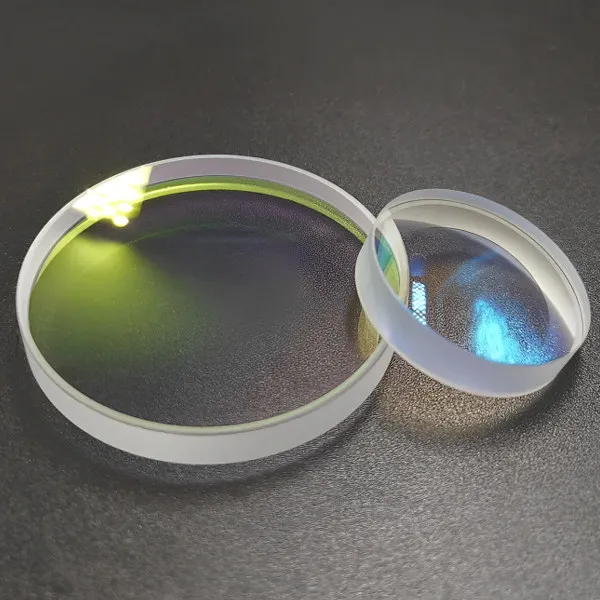 Two positive meniscus lenses on a grey textured surface