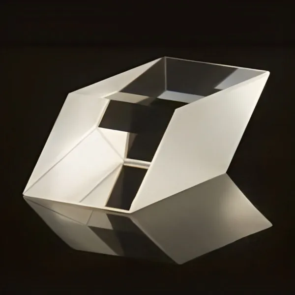 Rhomboid prism and its reflection on a dark surface